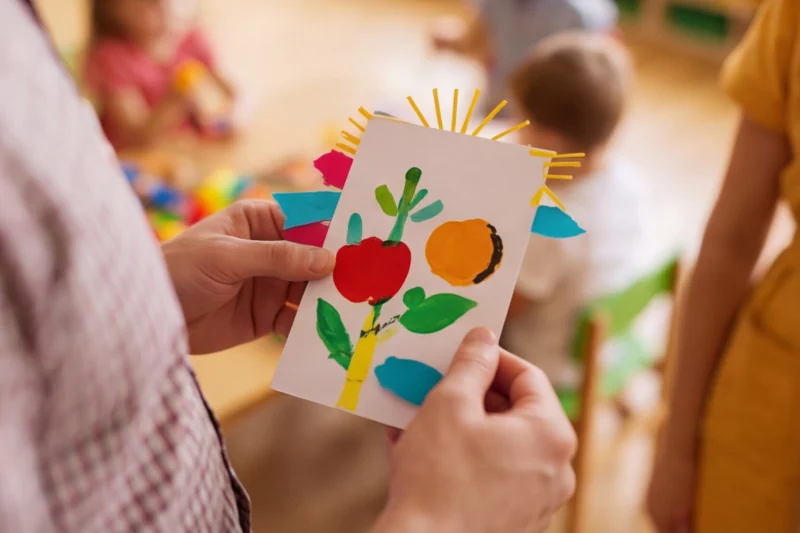 Die Hand eines Mannes hält eine gebastelte Karte in der Hand